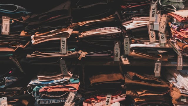 Neatly folded clothes with price tags on shelves in a Taipei shop.