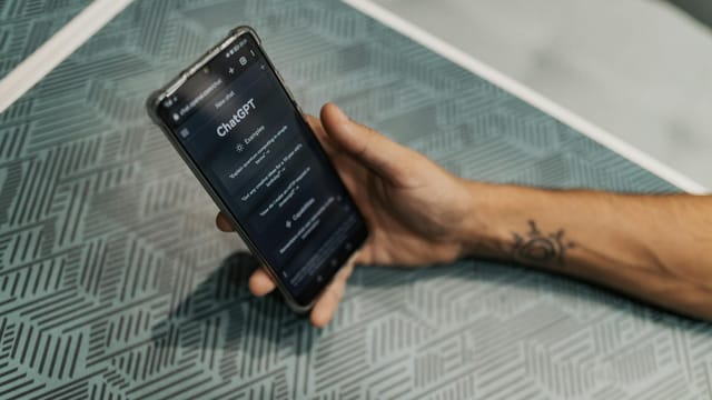 Close-up of a smartphone in hand with ChatGPT on the screen, symbolizing AI technology