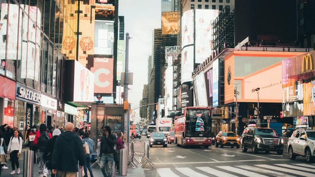 Busy Times Square in NYC, bustling with people, billboards, and traffic.