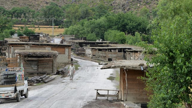 A serene rural village in Afghanistan, showcasing traditional architecture and lush greenery.