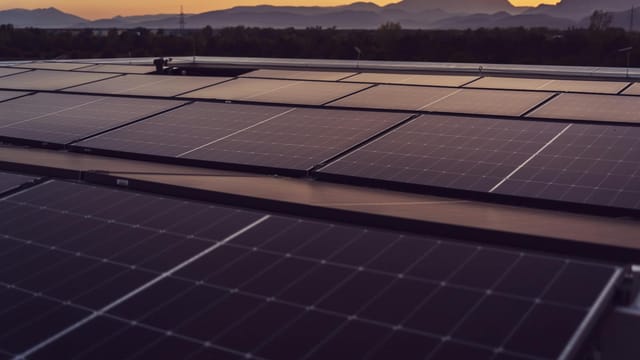 Solar panels in Styria, Austria under a serene sunset, showcasing renewable energy.
