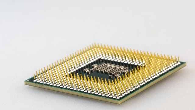 A detailed close-up of a CPU microchip showcasing its intricate gold pins and technology.