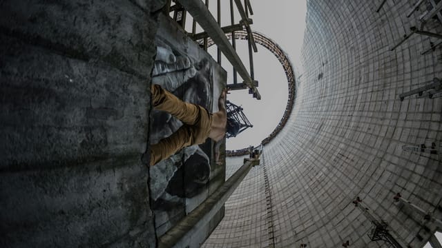 A daring man climbs inside a massive cooling tower in Pryp'yat', Ukraine.
