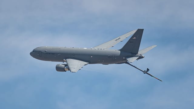 US Air Force KC-46 Pegasus plane in flight, showcasing air refueling capability against a blue sky.