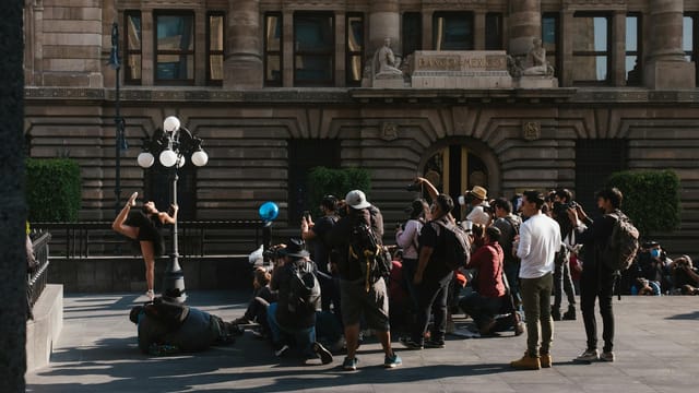 Energetic street performance with photographers capturing the moment outside Banco building.