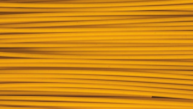Close-up shot of uncooked yellow pasta spaghetti showcasing texture and pattern.
