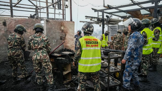 Nepali Army rescuers in action at a disaster site, collaborating amidst damaged infrastructure.
