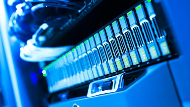 A detailed view of a blue lit computer server rack in a data center showcasing technology and hardware.