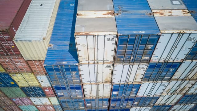 Aerial view showing colorful stacked cargo containers at a shipping yard.