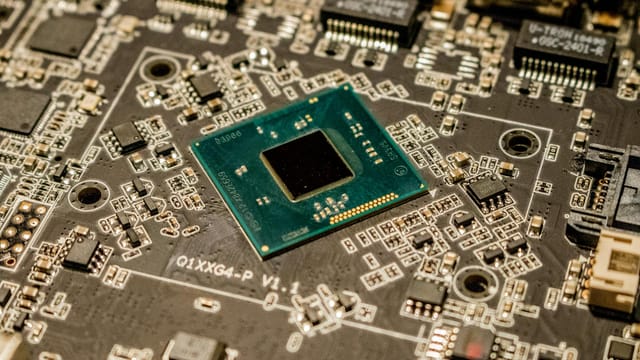 Detailed view of a microchip on a printed circuit board, showcasing electronic components.
