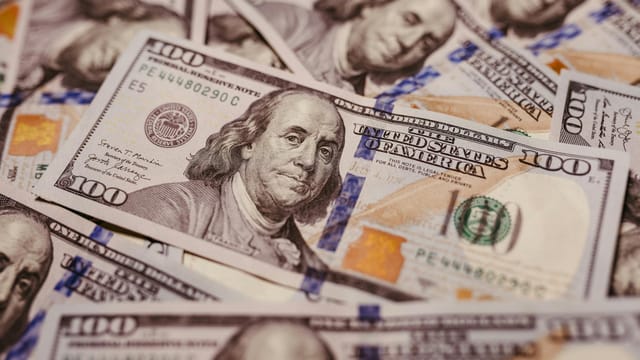 Pile of 100 dollar bills depicting wealth and financial success in close-up view.