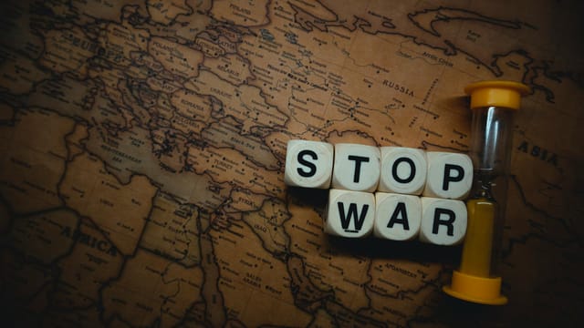 A powerful message 'Stop War' displayed on a vintage world map with an hourglass, symbolizing urgency and global issues.
