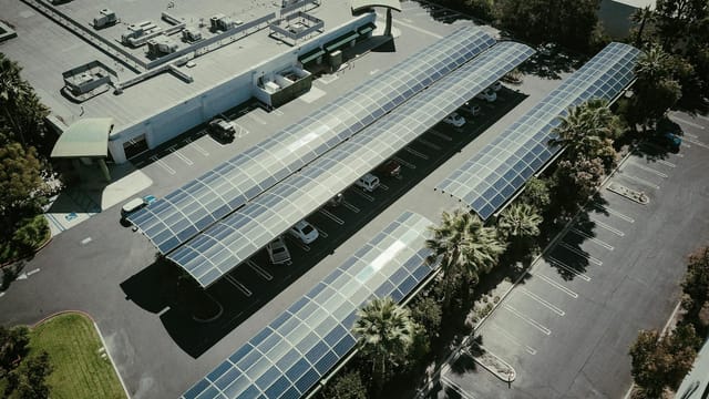 Aerial view of solar panels on a parking lot roof, showcasing renewable energy.