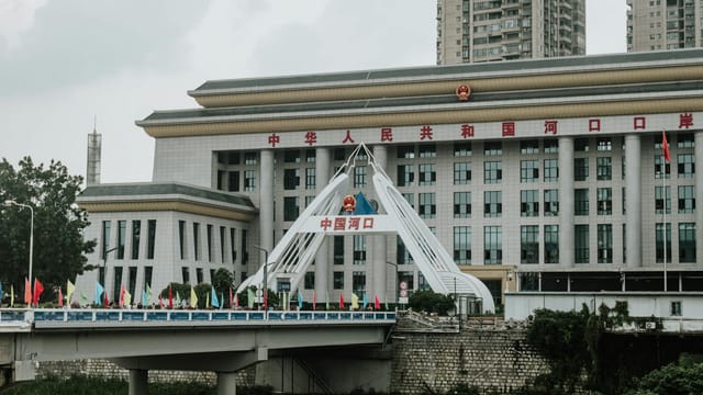 Urban scene featuring a bridge and government building in China.