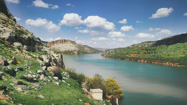 Explore the serene landscape of Ana, Iraq with lush greenery and a tranquil river.