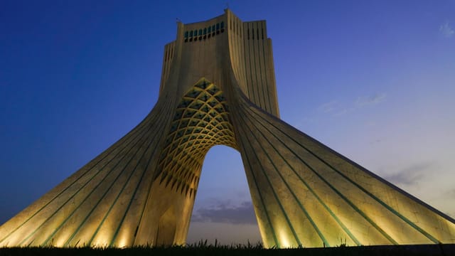 A captivating view of the Azadi Tower in Tehran against a blue twilight sky.