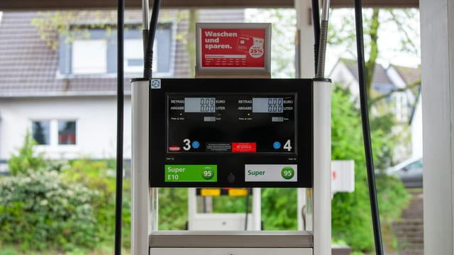 Close-up of a gas pump at a station in Bergisch Gladbach, Germany, with surrounding houses visible.