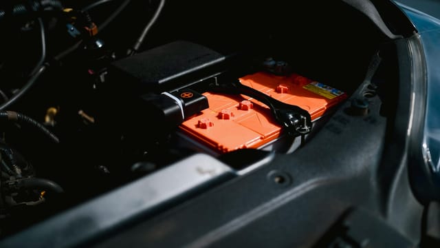 Detailed view of an electric car battery inside a vehicle's engine compartment, highlighting sustainable technology.