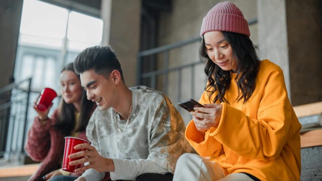Young adults enjoying a casual hangout indoors, capturing moments and sharing laughter.