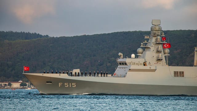 Istanbul-class multi-role frigate F515 sailing with Turkish flags and crew on deck.