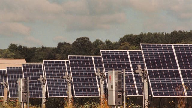 Solar panels in a field generating clean, renewable energy on a sunny day.