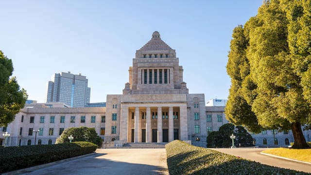 Front view of the National Diet Building in Tokyo on a sunny day, showcasing classic architecture.