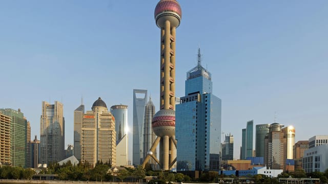 View of the Shanghai skyline with the iconic Oriental Pearl Tower at sunset.