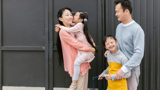 Asian family embracing and enjoying time together outdoors, showcasing love and inclusion.