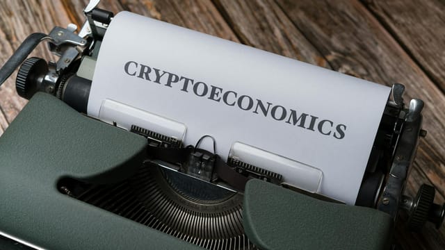 Cryptoeconomics typed on paper using vintage typewriter on wooden background.