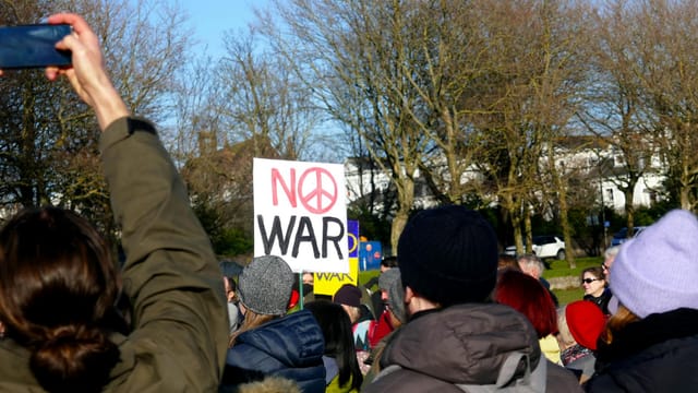 Crowd in Brighton, England, protesting against war with signs and peaceful demonstration.