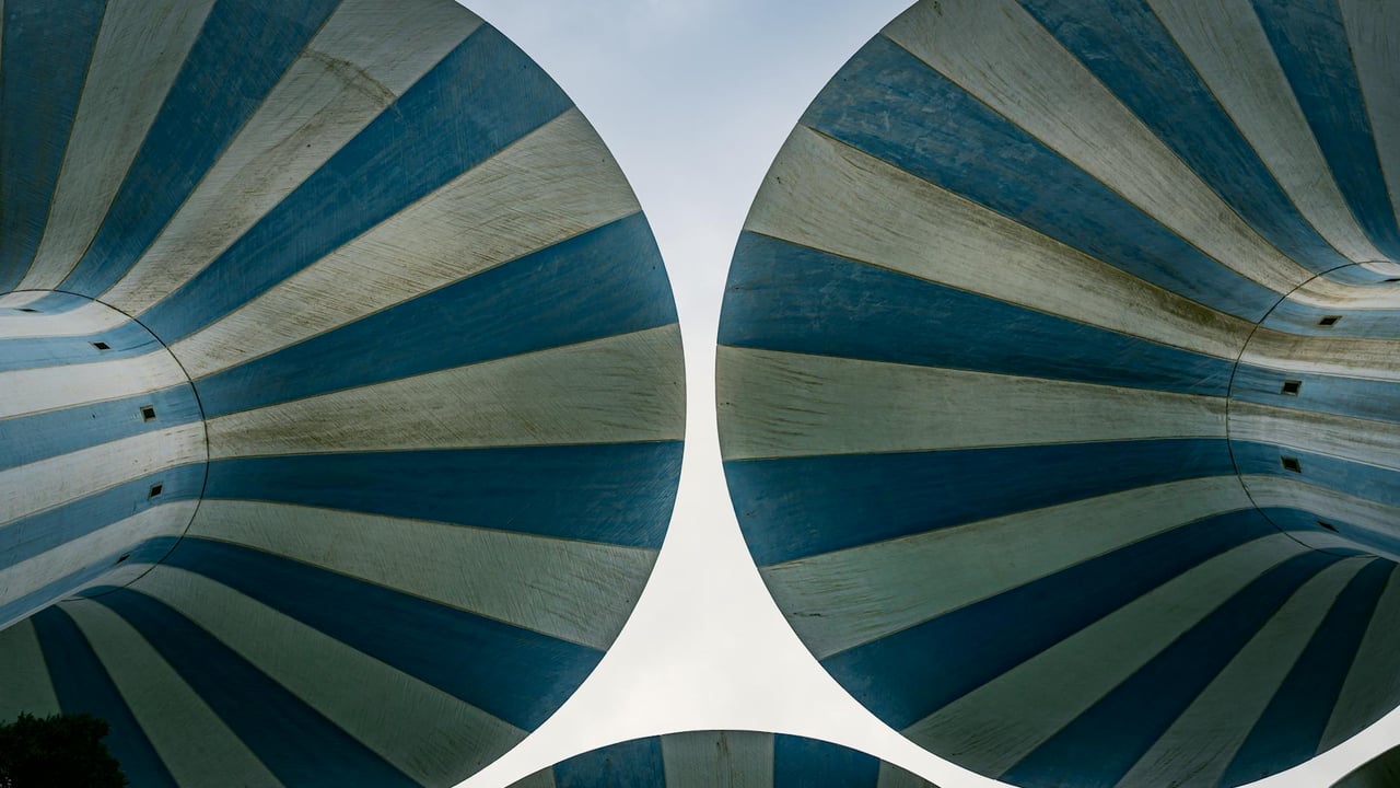 Unique view of blue and white striped water towers in Kuwait City, showcasing Arabian architecture.