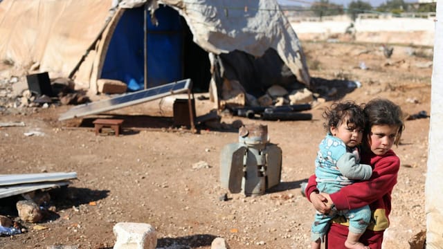 A touching scene of children in a refugee camp in Idlib, Syria, highlighting resilience.
