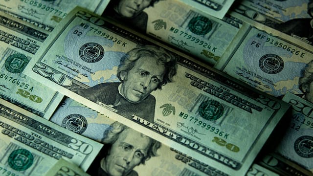 Close-up of multiple US twenty dollar bills depicting wealth and finance.