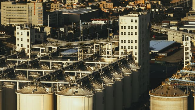 Aerial view of industrial silos with cityscape in Xiamen, China.