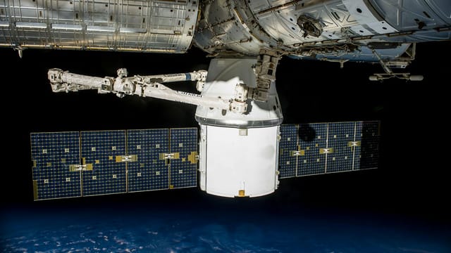 A satellite with solar panels orbiting Earth, capturing the vast universe.