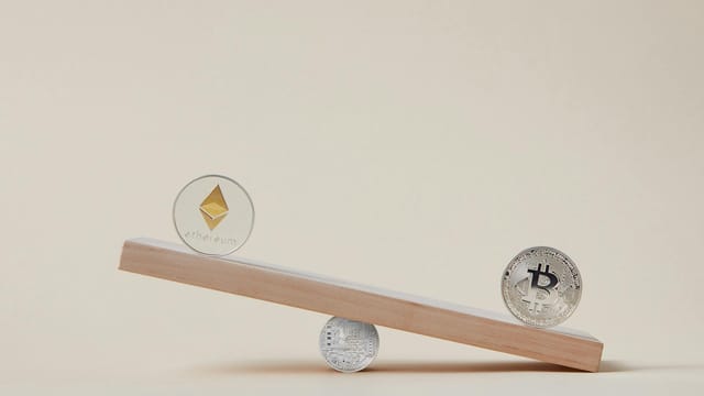 Minimalist image of Ethereum and Bitcoin coins balancing on a plank, symbolizing crypto market dynamics.