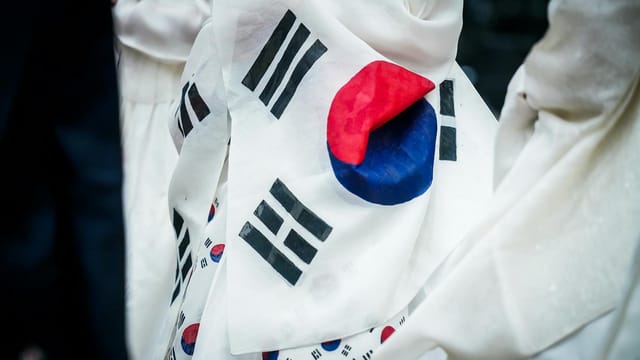 A detailed close-up of the wrinkled South Korean flag on fabric, showcasing its vibrant colors.