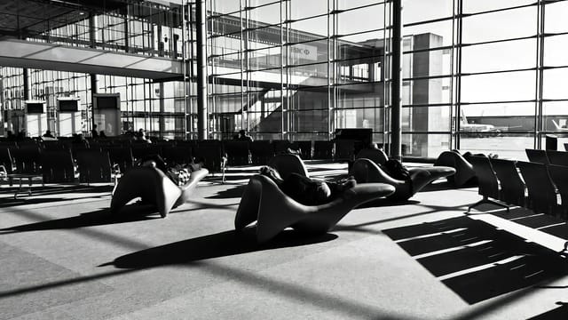 A modern airport lounge in Roissy-en-France, France, captured in monochrome with unique seating arrangements.