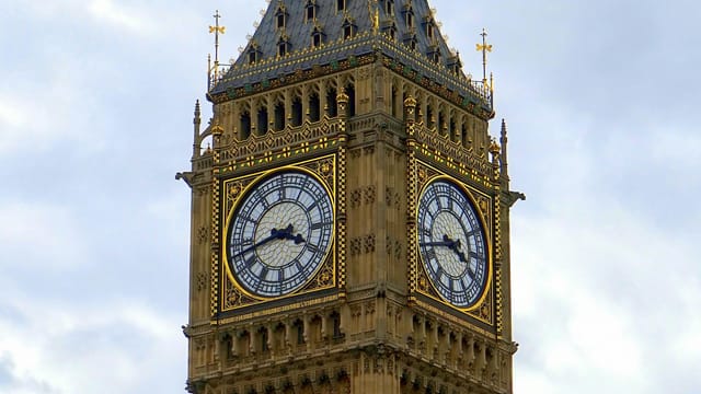 Close-up of the famous Big Ben clock tower against a cloudy sky in London, England.