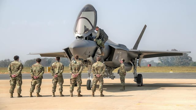 Soldiers observing a fighter jet at an air show in Bengaluru, India.