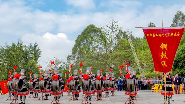 Cultural drum performance outdoors in Guangxi, China, showcasing traditional attire.