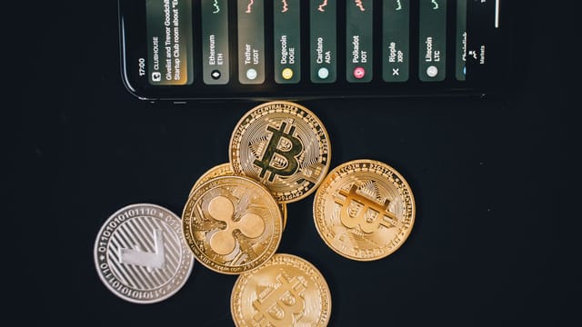 Close-up of various cryptocurrencies and a smartphone showing market trends.