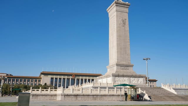 Monument to the People's Heroes in Tiananmen Square, Beijing, China, under a clear blue sky.