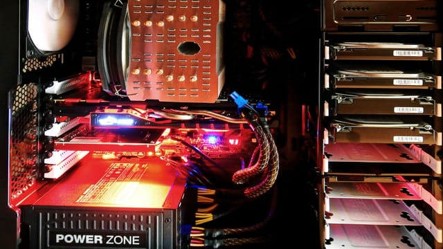 Close-up of a custom gaming PC with RGB lighting, showcasing power supply and components.