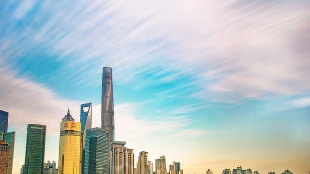 Shanghai skyline featuring iconic skyscrapers against a colorful dawn sky. Ideal for urban and architecture themes.