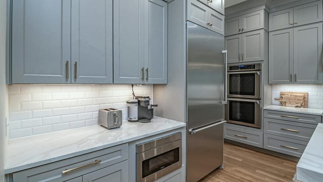 Sleek modern kitchen featuring stainless steel appliances and light grey cabinets.