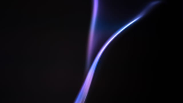 Vibrant abstract gradient resembling a flame against a dark backdrop, showcasing smooth color transitions.