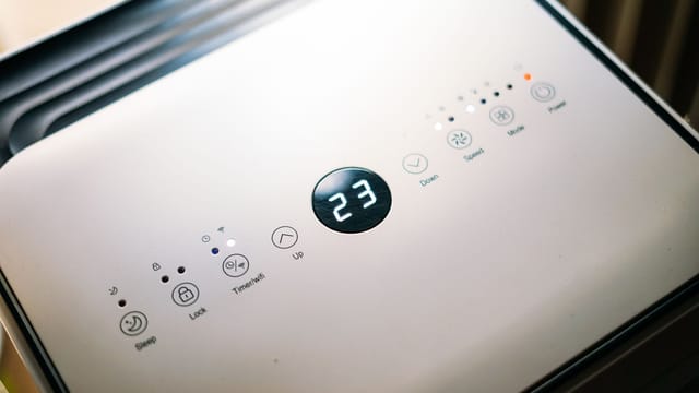 Close-up of a sleek air conditioner control panel displaying temperature.