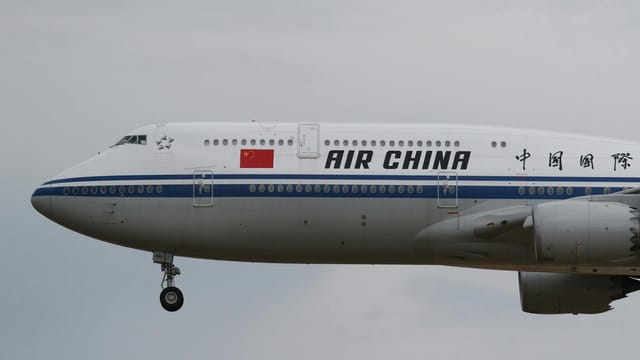 Side view of an Air China Boeing 747 aircraft flying over Frankfurt, Germany.