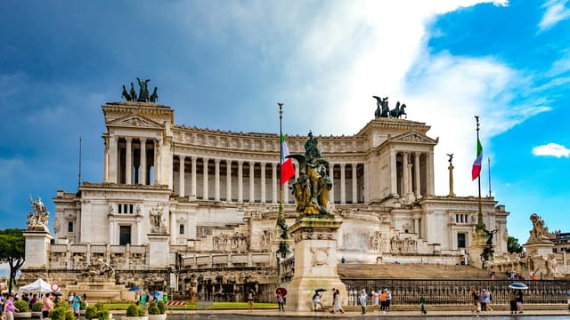 Stunning view of the Vittoriano Monument in Rome's Piazza Venezia with Italian flags and statues.